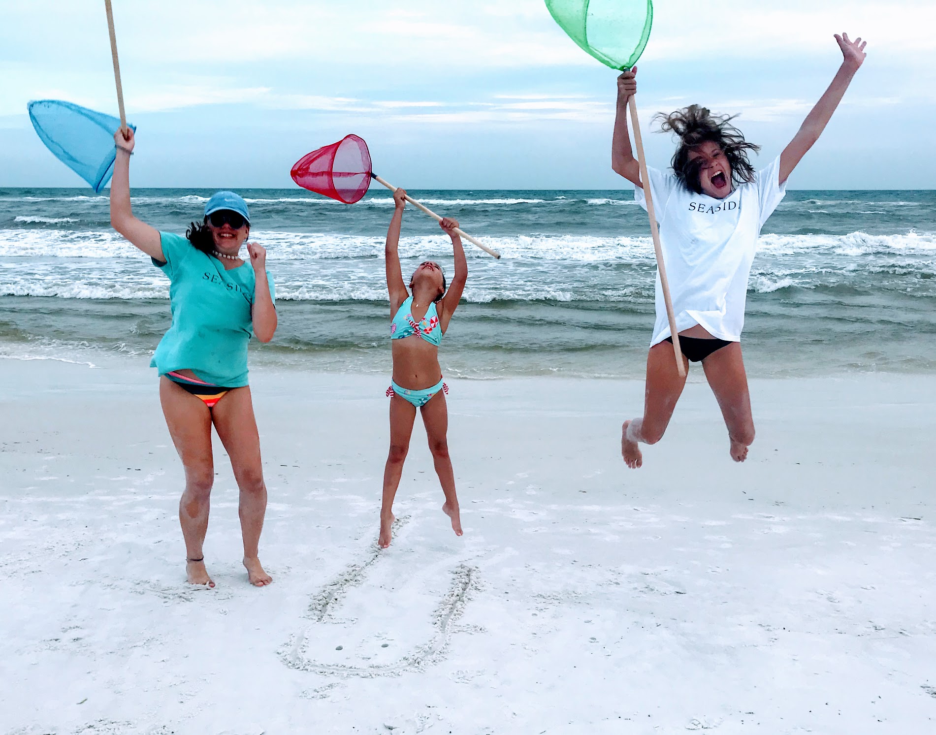 three girls jumping on beach