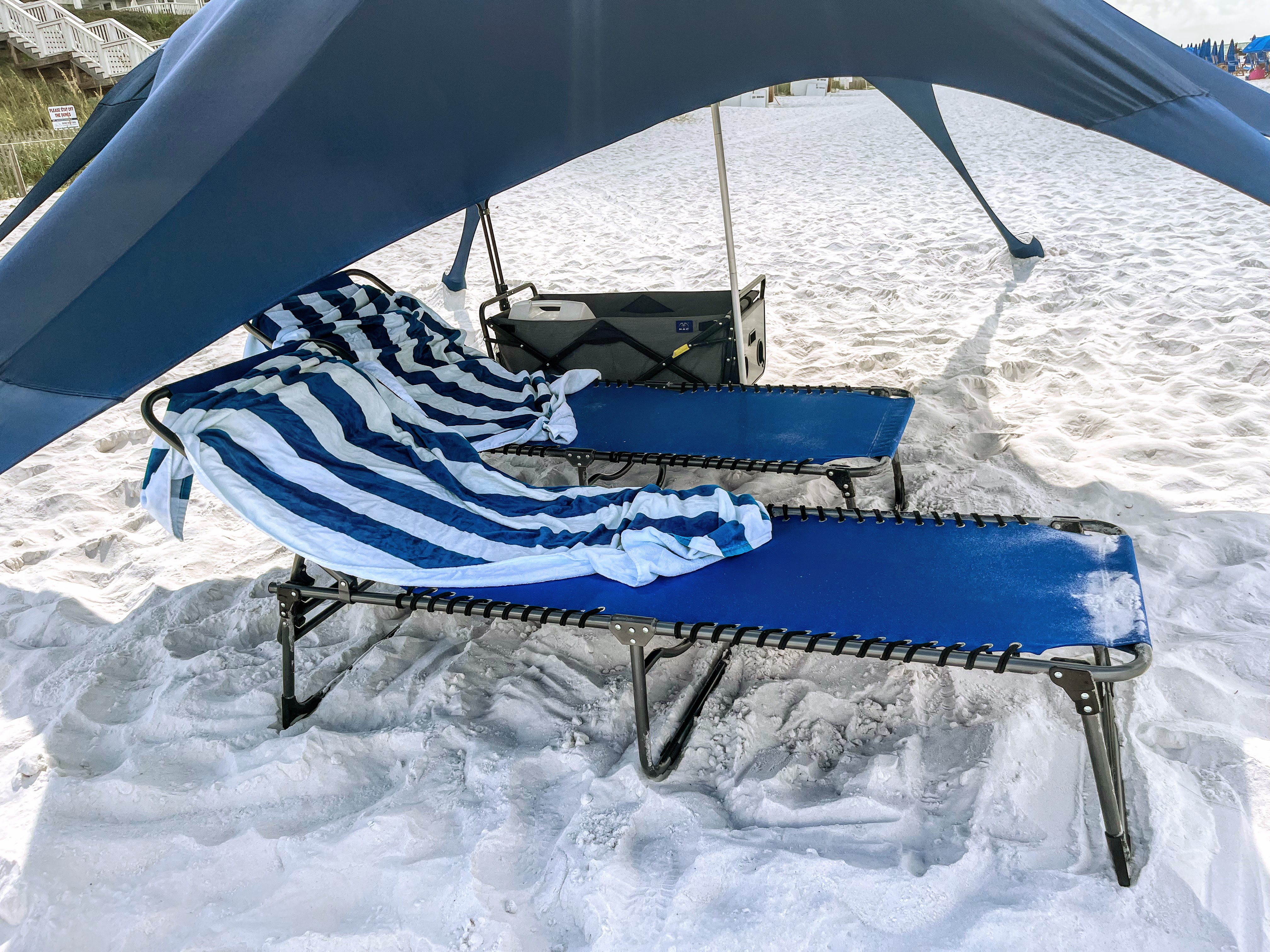 two blue folding chaise lounge chairs under canopy