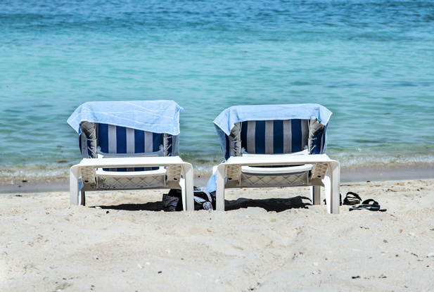 two beach chaise lounges by the ocean