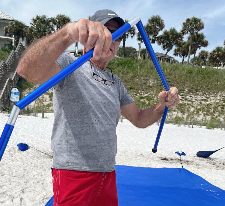 man holding telescoping beach canopy tent poles