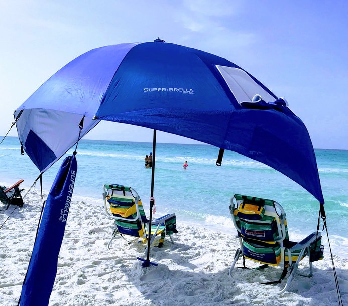 blue Sportbrella beach umbrella set up with beach chairs
